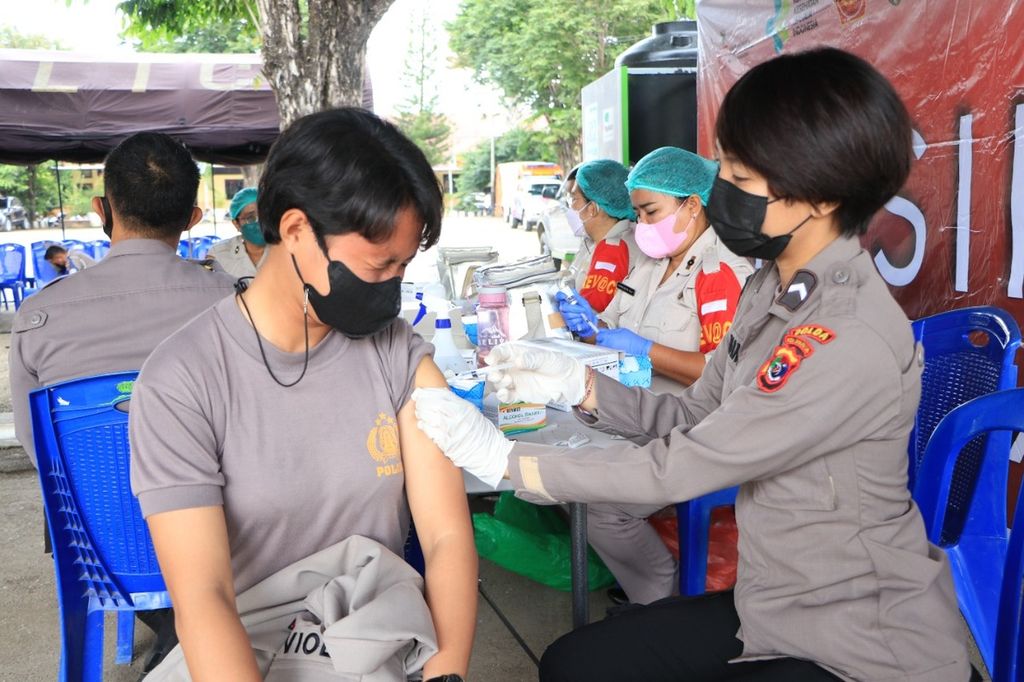 Seorang anggota Polwan Kepolisian Daerah Nusa Tenggara Timur sedang menerima vaksin <i>booster </i>atau vaksin penguat di Polda NTT, Senin (21/2/2022). Tampak polwan tersebut meringis kesakitan saat jarum masuk ke tubuh.