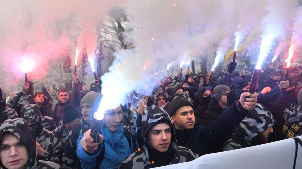 Unjuk rasa warga Ukraina menyalakan suar saat mengikuti demonstrasi di depan parlemen Ukraina di Kiev (26/11/2018). Mereka menuntut pemberlakuan darurat militer dan memutus hubungan diplomatik dengan Rusia setelah angkatan laut Rusia menyita tiga kapal Ukraina di lepas pantai Crimea.