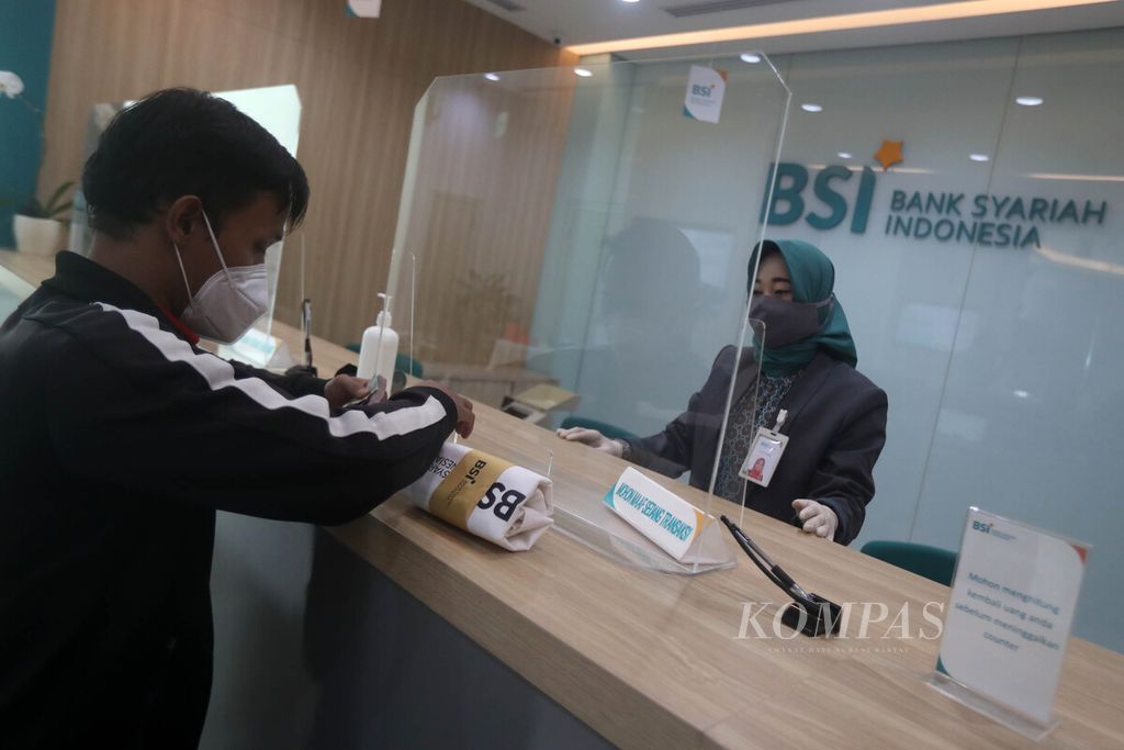 Teller Bank Syariah Indonesia melayani nasabah di Kantor Cabang Hasanudin, Blok M, Jakarta, Senin (1/2/2021). 