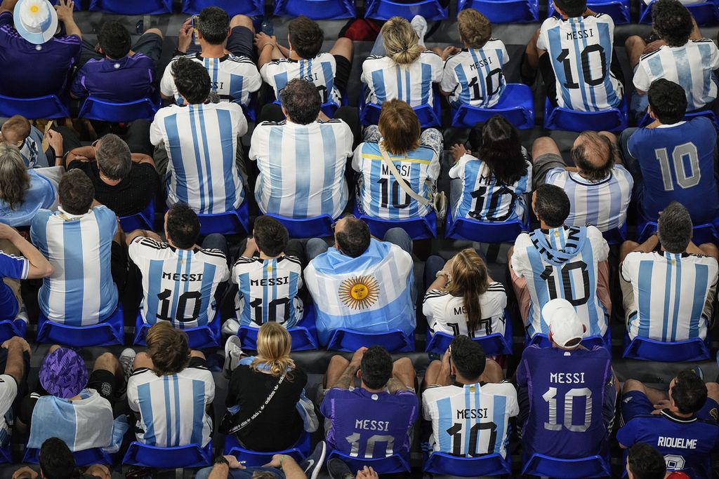 Para penggemar Argentina memakai kaus timnas Argentina yang bernomor 10 dan bertuliskan nama Lionel Messi, saat menonton laga Argentina melawan polandia pada penyisihan Grup C di Stadion 974, di Doha, Qatar, Rabu (30/11/2022). 