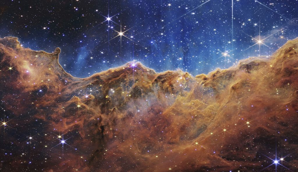Gambar yang dirilis oleh NASA pada hari Selasa (12/7/2022) ini menunjukkan tepi daerah pembentuk bintang muda di dekatnya, NGC 3324 di Nebula Carina. Menurut NASA, gambar ini mengungkapkan area kelahiran bintang yang sebelumnya dikaburkan yang tertangkap dalam cahaya inframerah oleh Near-Infrared Camera (NIRCam) di Teleskop Luar Angkasa James Webb.