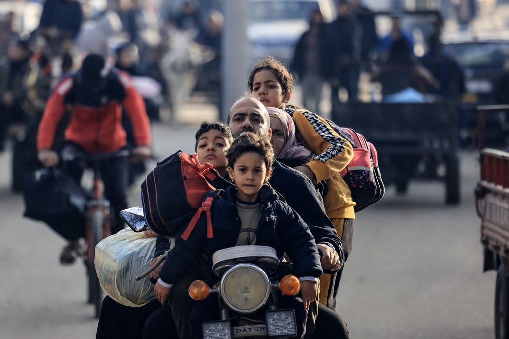 Keluarga Palestina mengendarai sepeda motor saat mereka bergerak menuju daerah yang lebih aman menyusul dimulainya kembali serangan Israel terhadap Rafah di Jalur Gaza pada 1 Desember 2023. 