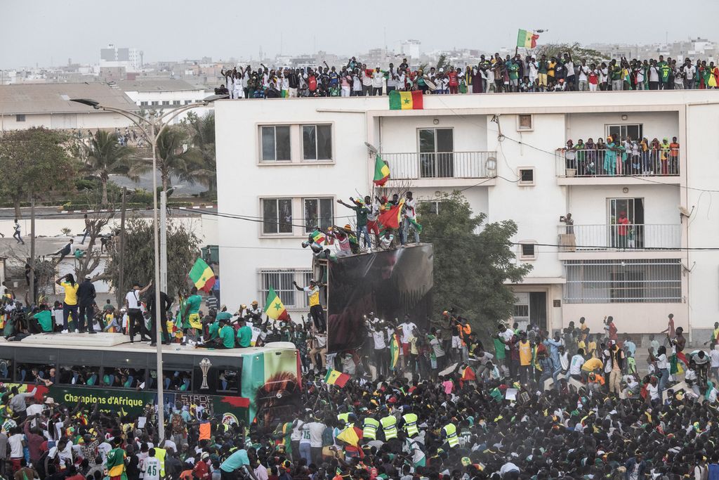 Pendukung menyambut tim sepak bola Senegal yang diarak keliling kota Dakar, Senagal, Senin (7/2/2022),