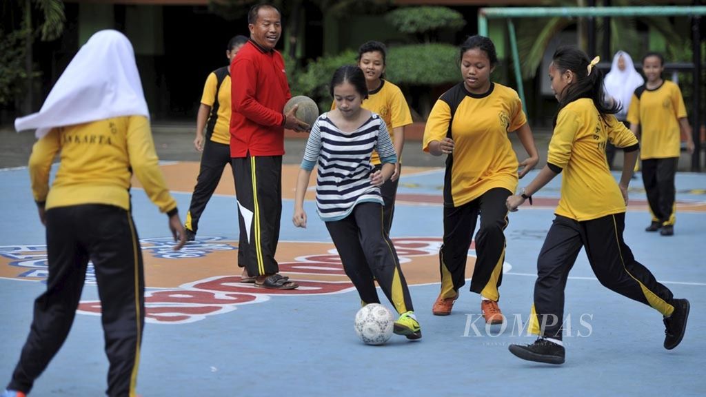 Sejumlah siswa SMP Negeri 40 Jakarta mengikuti kegiatan ekstrakurikuler futsal di halaman sekolah, Kamis (18/2/2016). Ekstrakurikuler futsal yang baru diperkenalkan di sekolah tidak hanya diminati siswa laki-laki, tetapi juga siswa perempuan. 