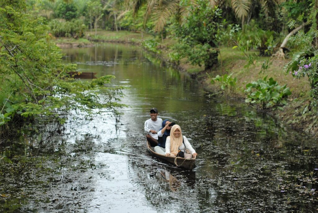 Sejumlah pengunjung menyusuri kanal tua di Taman Sakat di Desa Jambi Tulo, Maro Sebo, Kabupaten Muaro Jambi, yang dikenal sebagai desa pelestarian anggrek hutan. Di Taman Sakat, selain menikmati puluhan spesies anggrek endemik setempat, wisatawan juga dapat menikmati suguhan kopi nira.