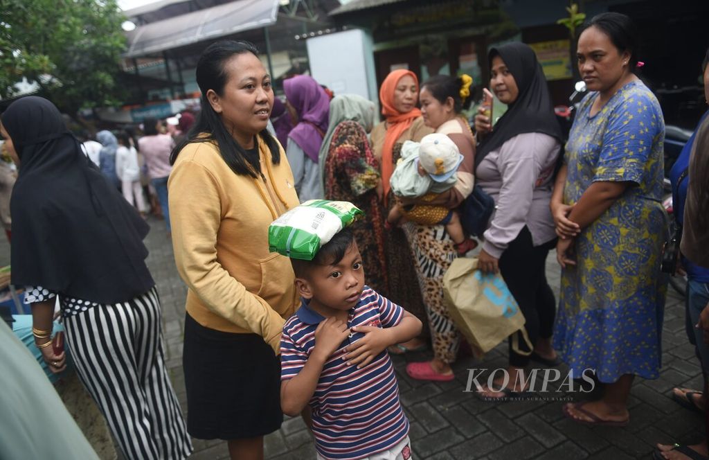 Seoarang anak membawa gula pasir yang dibeli saat pasar murah di Kantor Kelurahan Putat Jaya, Kecamatan Sawahan, Surabaya, Selasa (12/3/2024). 