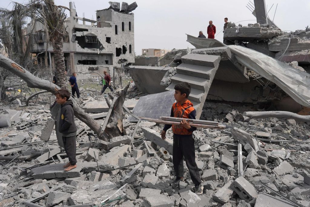 Palestinian children amidst building rubble caused by Israeli bombing in Gaza on Friday (29/3/2024).