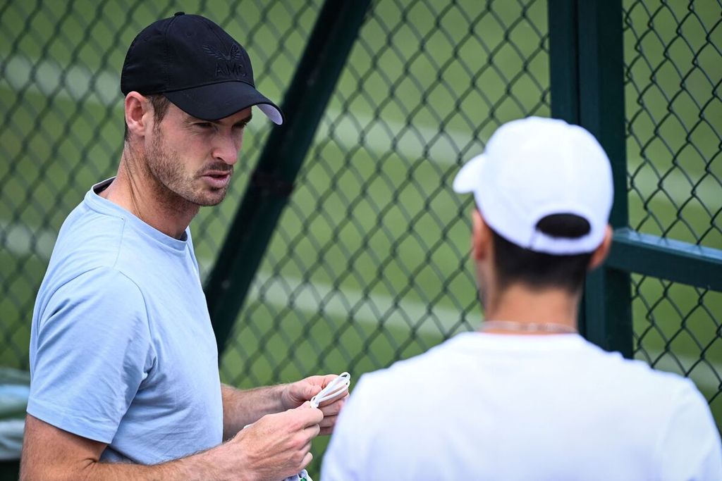 Petenis Inggris Raya, Andy Murray (kiri), berbincang dengan petenis Serbia, Novak Djokovic, saat tiba untuk berlatih di kompleks All England Tennis Club, Wimbledon, London, Minggu (26/6/2022). 