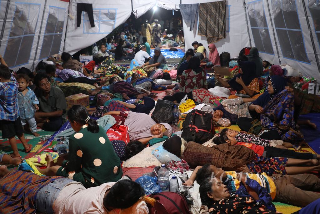 Pengungsi beristirahat di tenda yang didirikan di halaman Kantor Bupati Pasaman Barat, Sumatera Barat, Sabtu (26/2/2022) malam. Mereka merupakan warga korban gempa bermagnitudo 6,1 dari sejumlah tempat di Pasaman Barat. 