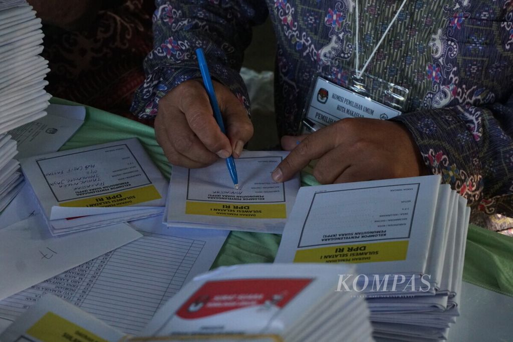 Anggota KPPS 42 menuliskan nama kota, kelurahan, kecamatan, dan nomor TPS di surat suara yang baru datang pada pukul 06.00 Wita.