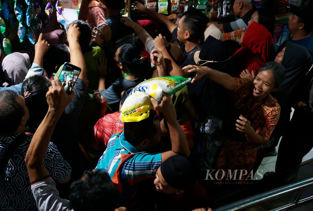 Warga berebut beras yang dibagikan salah satu lapak pedagang saat Menteri Perdagangan Zulkifli Hasan berkunjung di Pasar Bulu, Kota Semarang, Jawa Tengah, Selasa (20/2/2024). 