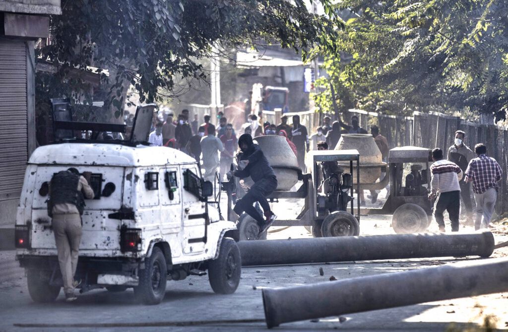 Seorang pengunjuk rasa Kashmir melempari kendaraan polisi India dengan batu di Srinagar, Kashmir. Bentrokan anti-India meletus di kota utama Kashmir yang dikuasai India pada hari Senin (17/12/2018) setelah dua gerilyawan tewas dalam baku tembak dengan pasukan pemerintah.