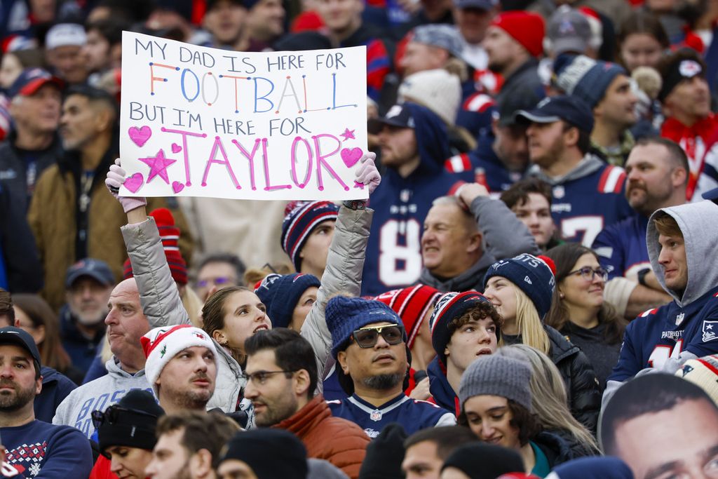 Seorang penggemar New England Patriots mengangkat tanda untuk Taylor Swift selama paruh pertama pertandingan sepak bola NFL melawan Kansas City Chiefs pada 17 Desember 2023, di Foxborough, AS. 