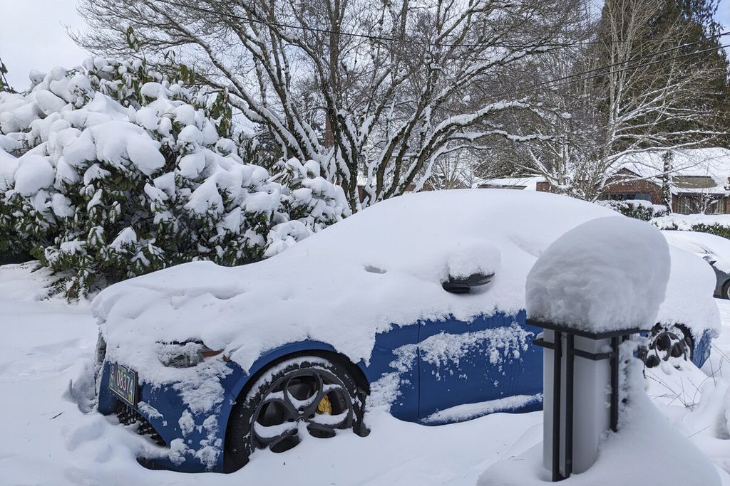 Salju menutupi sebuah mobil di Portland, Oregon, Kamis (23/2/2023). Badai musim dingin tersebut sebagai salah satu yang terburuk dalam sejarah hingga menutup sebagian wilayah Portland dan daerah lainnya di Amerika Serikat. 