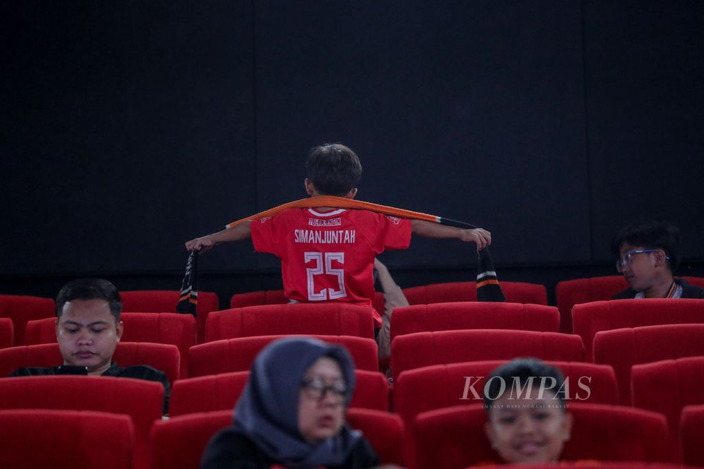 Anak mengalungkan syal Persija ke bahunya saat nonton bareng laga Madura United vs Persija Jakarta dalam gelaran Liga 1 di Cinepolis Senayan Park, Jakarta, Minggu (13/8/2023).
