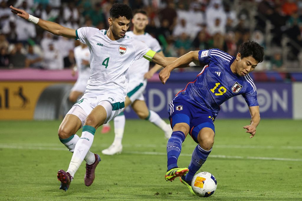 Iraqi defender, Zaid Tahseen (left), guards Japanese striker, Mao Hosoya, during the semi-final match of the 2024 U-23 Asia Cup between Japan and Iraq at Jassim Bin Hamad Stadium in Doha, on Tuesday (30/4/2024) early morning WIB.