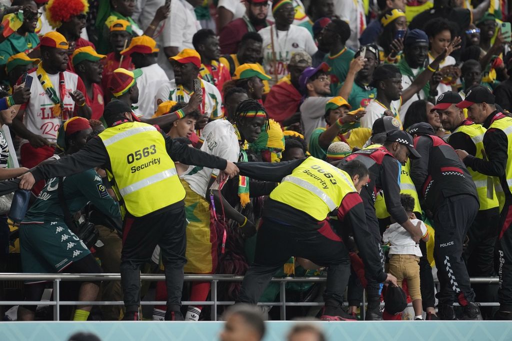 Petugas keamanan mencoba mencegah suporter masuk ke lapangan usai laga Grup A Piala Dunia Qatar 2022 antara Ekuador dan Senegal di Stadion Internasional Khalifa, Doha, Qatar, Tuesday, 29 November 2022. 