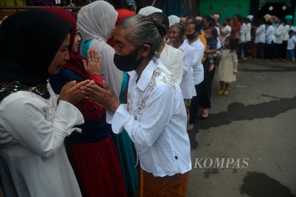 Warga non-Muslim mengantre bersalaman untuk bersilaturahim pada tetangga mereka yang merayakan Idul Fitri di Dusun Tekelan, Desa Batur, Kecamatan Getasan, Kabupaten Semarang, Jawa Tengah, Senin (2/5/2022). Tradisi ini merupakan wujud toleransi antarumat beragama. 