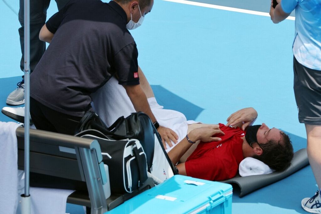 Petenis Komite Olimpiade Rusia (ROC), Daniil Medvedev, mendapat bantuan medis karena mengalami <i>heatstroke</i> pada laga babak ketiga Olimpiade Tokyo 2020 melawan petenis Italia, Fabio Fognini, di Ariake Tennis Park, Tokyo, Jepang, Rabu (28/7/2021).