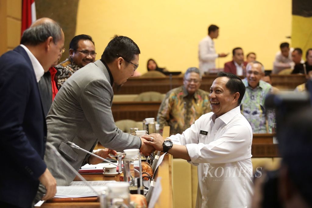 Menteri Dalam Negeri Tito Karnavian berjabat tangan dengan Ketua Komisi II DPR Ahmad Doli Kurnia Tanjung sebelum rapat kerja di Kompleks Parlemen, Senayan, Jakarta, Rabu (6/11/2019). 