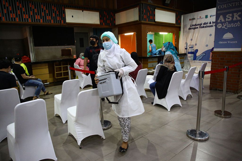 Petugas vaksinator membawa tambahan stok vaksin saat pelaksanaan vaksinasi massal di Bintaro Jaya Xchange Mall, Tangerang Selatan, Banten, Selasa (29/6/2021). Vaksinasi massal dengan target 2.500 orang tervaksin dalam sehari ini menggunakan vaksin Sinovac.
