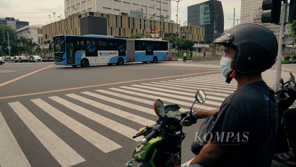 Bus Transjakarta melintas di perempatan Jalan Thamrin, Jakarta Pusat, Selasa (8/3/2022). Wilayah aglomerasi Jabodetabek kembali menerapkan PPKM level 2. 