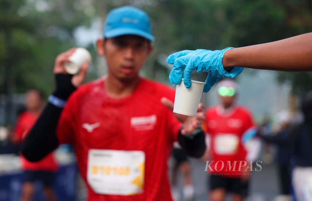 Petugas memberikan minum bagi peserta lari maraton pada ajang Borobudur Marathon 2023 Powered by Bank Jateng di kawasan Candi Borobudur, Kabupaten Magelang, Jawa Tengah, Minggu (19/11/2023).