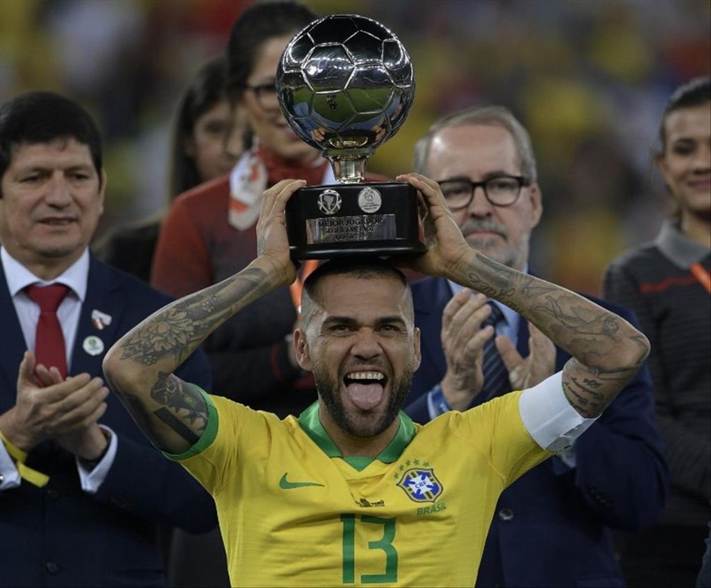 Dani Alves berpose dengan trofi pemain terbaik Copa America 2019 setelah mengalahkan Peru pada babak final dengan skor 3-1 di Stadion Maracana, Rio De Janeiro, Brasil, Senin (8/7/2019). 