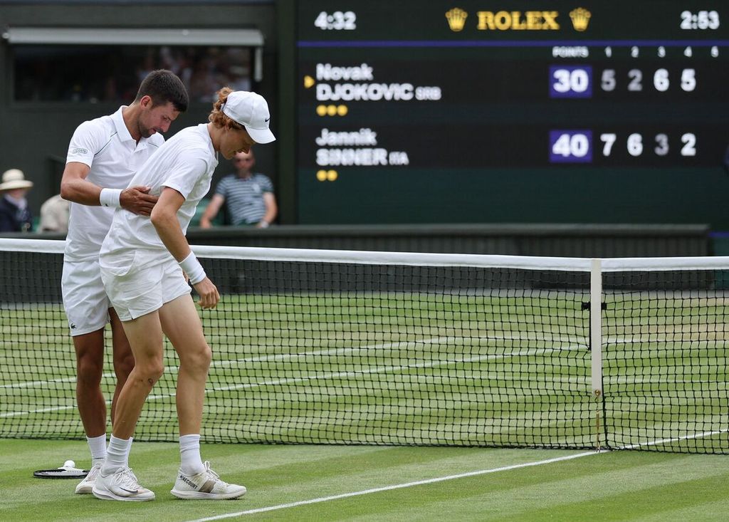 Petenis Serbia Novak Djokovic (kiri) membantu lawannya berdiri, yaitu petenis Italia Jannik Sinner yang terjatuh saat pertandingan perempat final Wimbledon di All England Tennis Club, Wimbledon, London, Selasa (5/7/2022). Djokovic menang setelah tertinggal dua set, 5-7, 2-6, 6-3, 6-2, 6-2. 