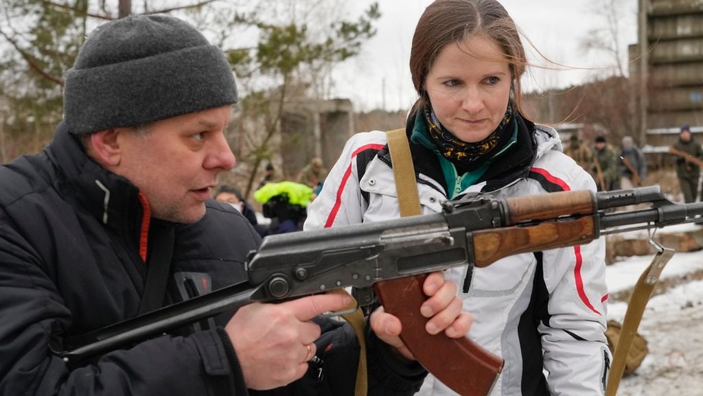 Seorang pelatih sedang melatih anggota Pasukan Pertahanan Wilayah Ukraina di Kiev, Ukraina, Januari lalu. Puluhan warga sipil bergabung dengan pasukan keamanan Ukraina karena khawatir dengan serangan Rusia. 