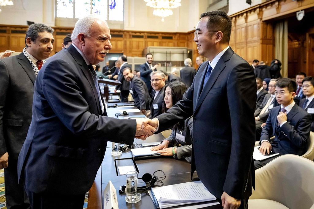 Palestinian Foreign Minister Riyad Maliki (left) shook hands with Ma Xinmin, the Director-General of the Treaty and Law Department of China's Ministry of Foreign Affairs (right), during the International Court of Justice session in The Hague, Netherlands on February 22, 2024, discussing the Israeli occupation in Palestinian territories.
