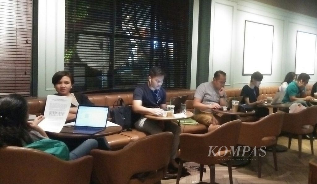 Sejumlah anak muda sibuk dengan komputer bergerak (laptop) di sebuah kedai kopi di Jakarta Pusat. Generasi milenial saat ini dikenal lebih senang bekerja tanpa batasan ruang dan waktu.