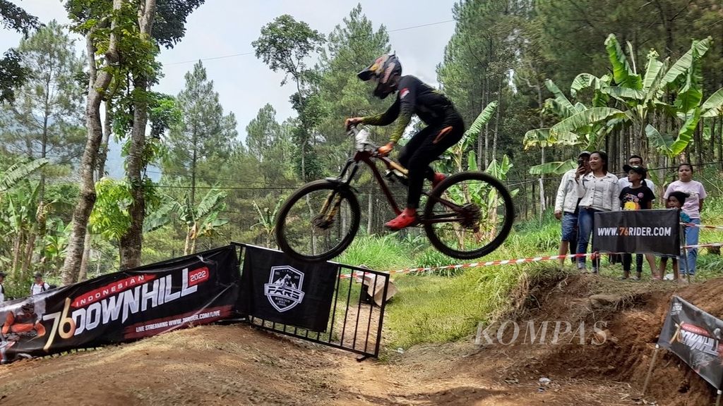 Seorang atlet downhill tengah melayang menaklukkan jalur Umbaran Bike Park di Desa Sidoluhur, Kecamatan Lawang, Kabupaten Malang, Jawa Timur, dalam final 76 Indonesian Downhill 2022, Minggu (18/9/2022).