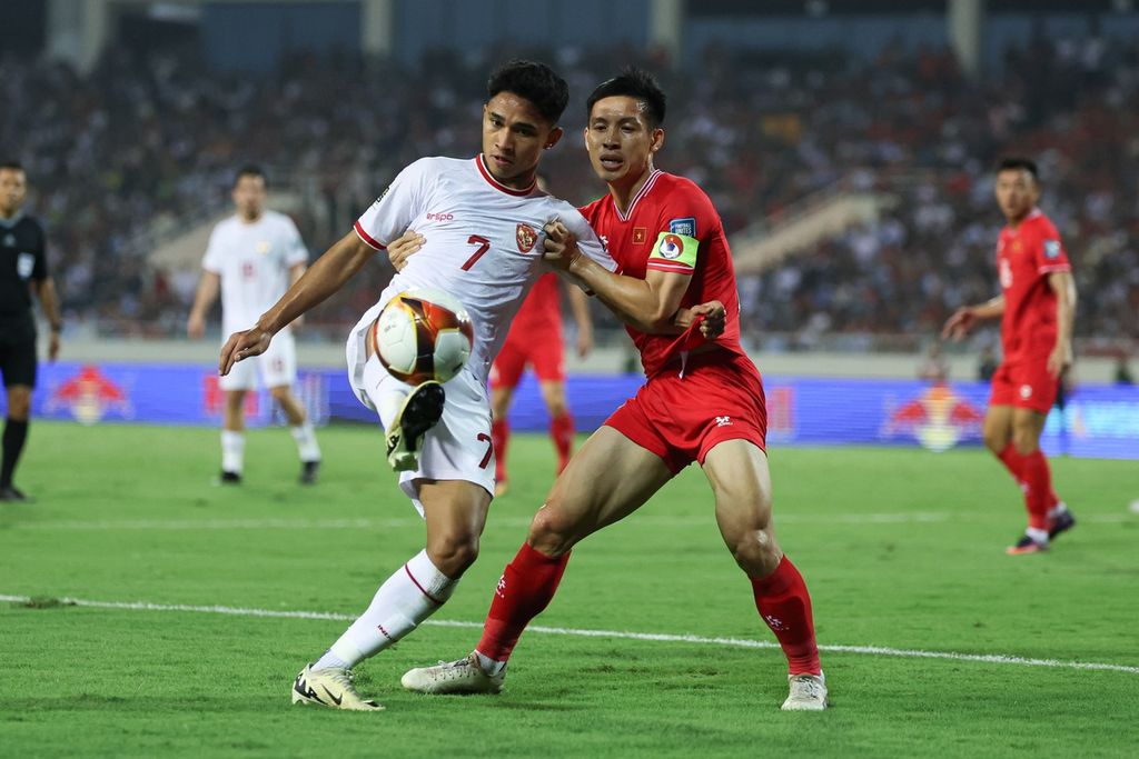 Gelandang Indonesia, Marselino Ferdinan (kiri), berebut bola dengan pemain Vietnam pada laga kualifikasi Piala Dunia 2026 di Stadion My Dihn, Hanoi, Selasa (26/3/2024). Indonesia memenangi laga dengan skor 3-0.