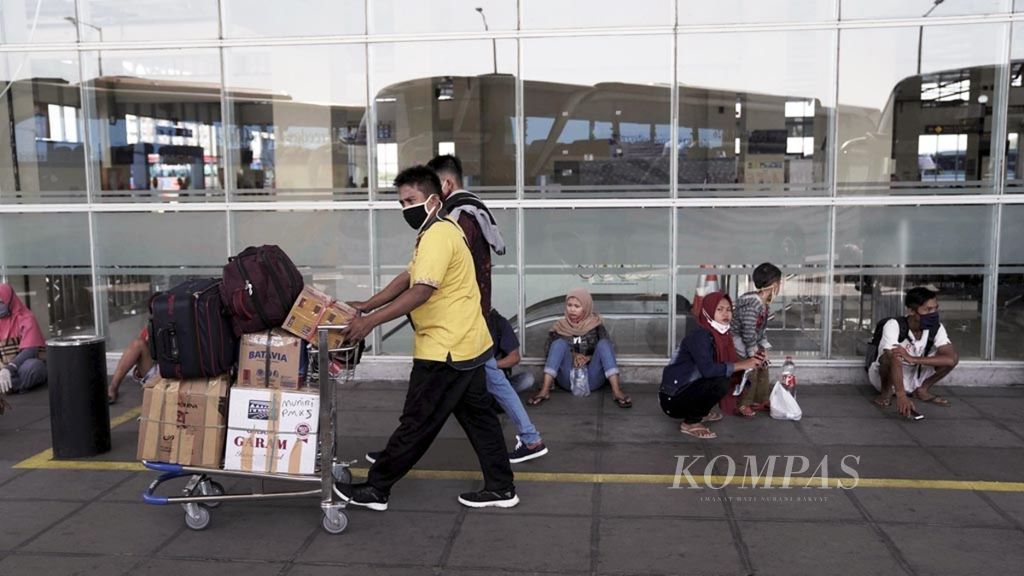 Porter membawa barang menuju keberangkatan bus antarkota antarprovinsi (AKAP) di Terminal Bus Terpadu Sentra Timur, Pulo Gebang, Jakarta Timur, Rabu (22/4/2020). Mulai 24 April, pemerintah menerapkan larangan mudik, terutama bagi warga wilayah merah pandemi Covid-19.