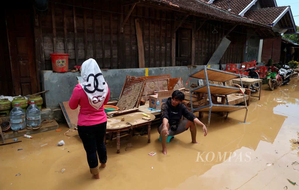 Warga berada di antara rumah dan jalan yang masih tergenang lumpur setelah banjir bandang menerjang Desa Sinomwidodo, Kecamatan Tambakromo, Kabupaten Pati, Jawa Tengah, Kamis (1/12/2022). 