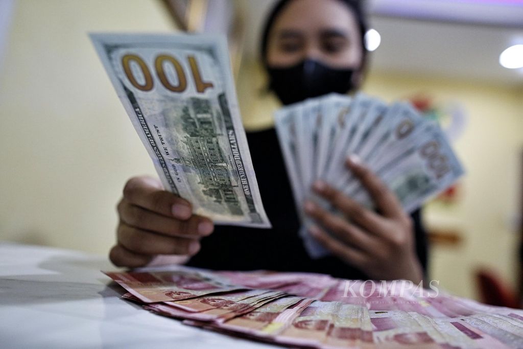 Petugas menunjukkan uang dollar Amerika Serikat di tempat penukaran valuta asing Dolarindo di kawasan Blok M, Jakarta Selatan, Rabu (27/7/2022).