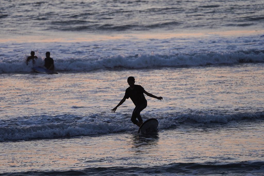 Pengunjung belajar <i>surfing</i> di Pantai Kuta, Bali, Senin (11/10/2021). 
