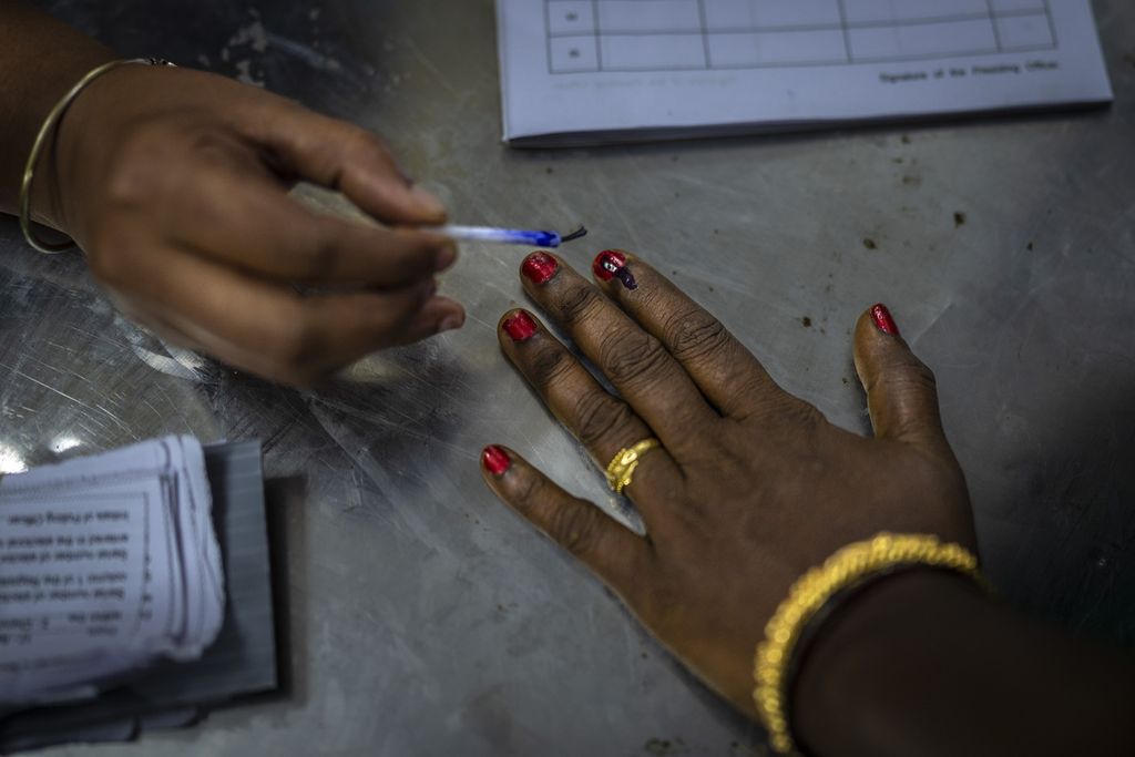 Petugas di tempat pemungutan suara membubuhkan tinta ke salah satu jari pemilih yang sudah menggunakan hak suaranya di  Chennai, Tamil Nadu, India, Jumat (19/4/2024). India mulai melaksanakan fase pertama pemilihan umum yang diikuti sekitar 166 juta pemilih.  