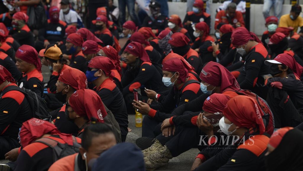 Para buruh duduk di depan pintu gerbang Gedung MPR/DPR/DPD, Senayan, Jakarta, saat berunjuk rasa, Senin (7/2/2022). Massa buruh dari Federasi Serikat Pekerja Metal Indonesia (FSPMI) dan elemen lainnya kembali berunjuk rasa dengan tuntutan menolak UU Cipta Kerja dan meminta revisi UMP/UMK di wilayah selain DKI Jakarta. 
