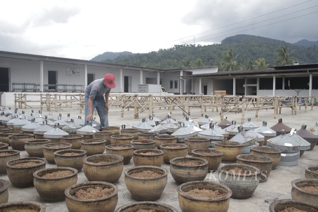 Pegawai pabrik Taoco Cap Meong, menutup guci yang berisi fermentasi kedelai di pabriknya di Jalan Raya Cipanas, Kabupaten Cianjur, Jawa Barat, Senin (28/2/2022). Fermentasi kedelai ini merupakan bahan baku taoco.