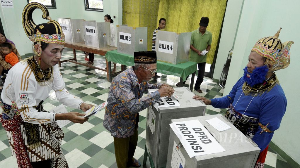 Warga lanjut usia menggunakan hak pilihnya di TPS 5 yang mengusung tema wayang di Panti Werdha Budhi Dharma, Kelurahan Giwangan, Umbulharjo, Yogyakarta, 9 April 2014. 