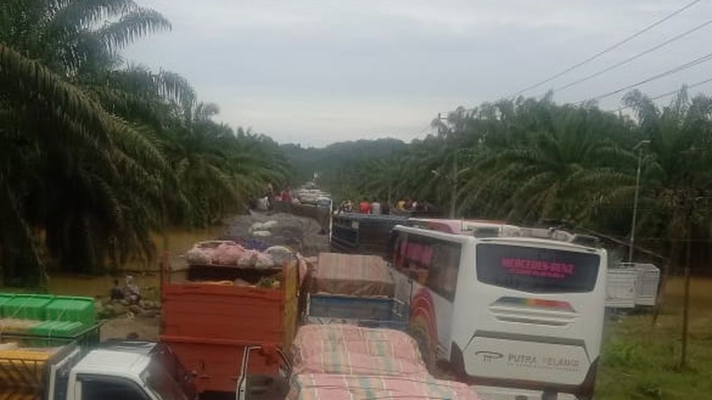 Kendaraan mengantre di Jalan Medan-Banda Aceh di Kabupaten Aceh Tamiang, Aceh, Jumat (4/11/2022). Jumat siang, hanya truk dan bus yang bisa melintasi jalan itu.