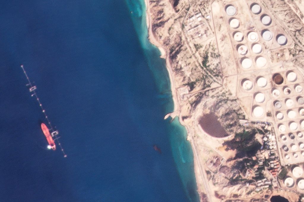 Tampak dalam foto satelit yang dikeluarkan Planet Labs PBC pada 16 Januari 2022 adalah kapal tanker Suez Rajan (kiri) di Pulau Khargh, Iran. Setelah AS menyita kapal itu pada April 2023, kapal itu berganti nama menjadi St Nikolas, yang disita Angkatan Laut Iran di Teluk Persia, Kamis (11/1/2024).  