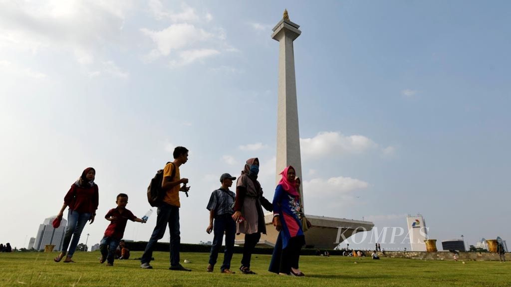Pengunjung menikmati suasana libur di Monumen Nasional, Jakarta, Kamis (6/6/2019). 