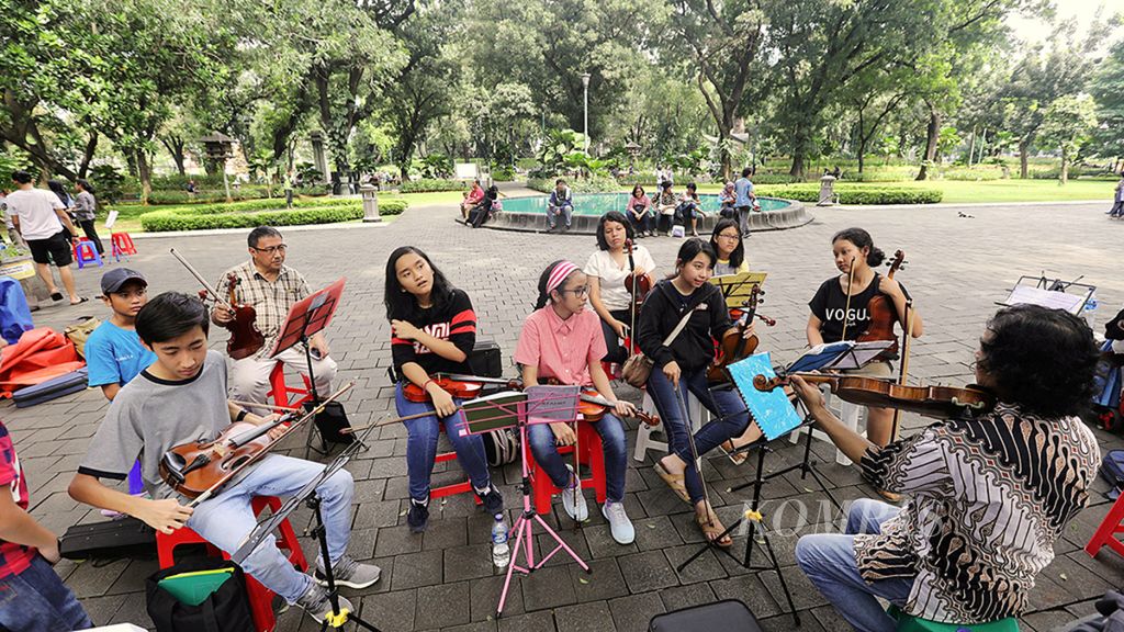 Sejumlah anggota komunitas berlatih memainkan biola di Taman Suropati, Menteng, Jakarta Pusat, Minggu (18/2). Taman kota yang nyaman tidak hanya menjadi paru-paru di tengah belantara beton Ibu Kota, tetapi juga dapat menjadi ruang bagi warga yang ingin melepaskan diri dari keruwetan kota, bersantai, sekaligus bersosialisasi.