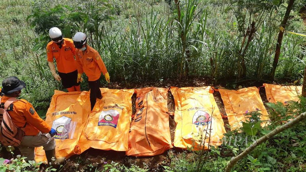 Petugas kepolisian mengecek sejumlah kantong berisi jenazah yang ditemukan terkubur di wilayah Kecamatan Wanayasa, Kabupaten Banjarnegara, Jawa Tengah, Senin (3/4/2023) siang. Sejumlah jenazah itu diduga merupakan korban pembunuhan oleh TH (45) alias Slamet. Slamet merupakan pelaku penipuan dengan modus penggandaan uang.