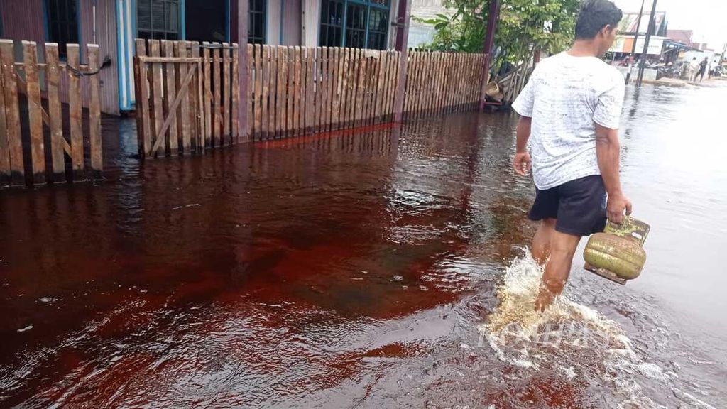 Warga melintas di tengah banjir yang merendam Jalan Anoi, Kelurahan Palangka, Kota Palangkaraya, Kalimantan Tengah, pada Kamis (9/2/2023). Di wilayah itu, banjir telah merendam selama dua hari.