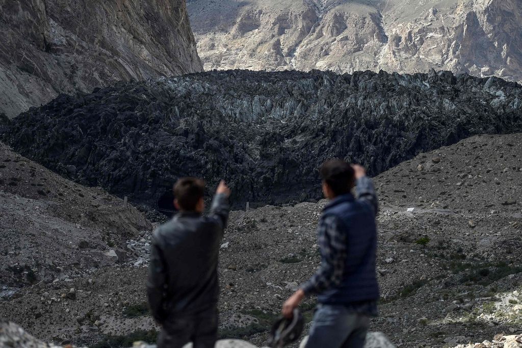 Dua pria menunjuk ke arah gletser Shisper di Gunung Karakoram, wilayah Gilgit-Baltistan, Pakistan, 28 Juni 2019. 