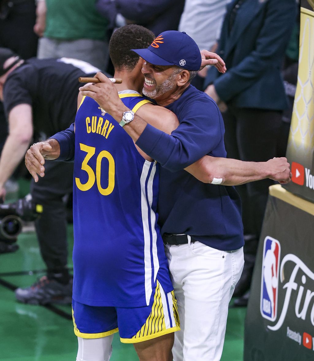 <i>Guard </i>Golden State Warriors Stephen Curry (kiri) memeluk ayahnya, mantan pemain NBA Dell Curry, di akhir laga keenam Final NBA antara Warriors dan Boston Celtics di TD Garden,  Boston, 16 Juni 2022. 